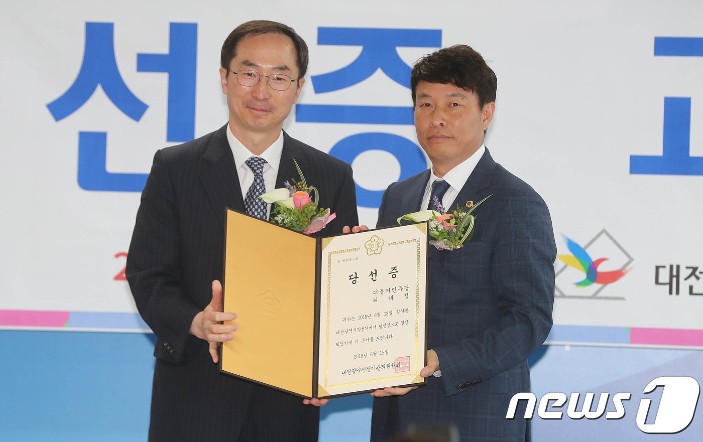 6.13지방선거에서 당선된 허태정 대전시장 당선인의 대리인 전문학 더불어민주당 대전시 선거대책본부장(오른쪽)이 15일 오전 대전 선거관리위원회에서 열린 당선증 교부식에 참석해 김필곤 대전시선관위 위원장으로부터 당선증을 전달받고 있다. 2018.6.15/뉴스1 ⓒ News1 주기철 기자