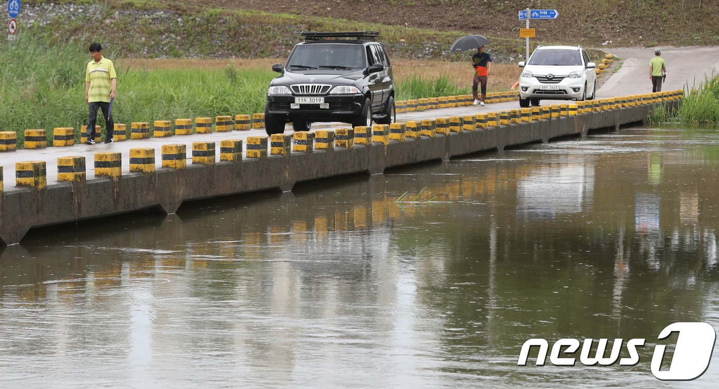 대전 서구의 한 다리에서 시민들이 밤사이 내린 비로 불어난 하천을 바라보며 걷고 있다. /뉴스1 ⓒ News1 주기철 기자