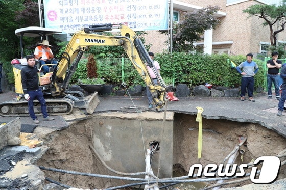지난 2일 오전 대전 서구 월평동 진달래아파트 네거리에서 도로가 침하돼 서구청 직원들이 긴급 복구작업을 벌이고 있다.ⓒ News1