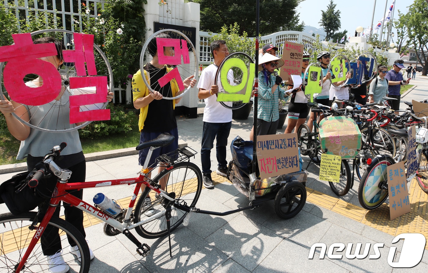 자전거문화사회적협동조합 등 시민단체 회원들이 21일 오후 서울청사 앞에서 기자회견을 열고 자전거 헬멧 착용 의무화 폐지를 촉구하고 있다. 이들은 "자전거 헬멧 착용 의무화와 같은 부상위험을 줄이는 정책보다 안전한 자전거 인프라 구축과 자전거 및 자동차 운전자들의 인식교육 등 사고발생 자체를 예방하는 정책이 우선돼야 할 것＂이라고 밝혔다. 2018.7.21/뉴스1 ⓒ News1 구윤성 기자