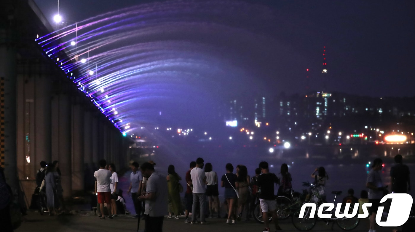 서울 낮 기온이 38도까지 오르며 1994년 이후 가장 높은 기온을 기록한 22일 오후 서울 서초구 반포한강공원에서 시민들이 반포대교 달빛무지개분수를 보며 더위를 식히고 있다. 2018.7.22/뉴스1 ⓒ News1 임세영 기자