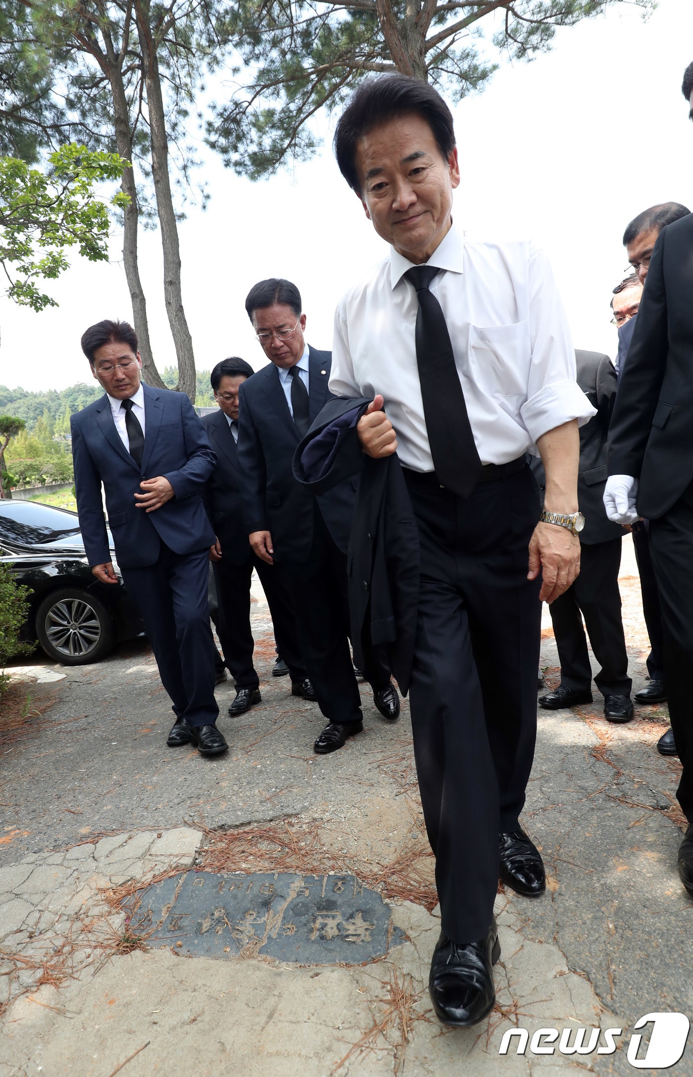 정동영 민주평화당 대표가 10일 오전 광주 북구 망월동 민족민주열사묘역에서 오월열사를 참배하러 가며 바닥에 설치된 전두환 전 대통령 기념비석을 지나치고 있다. .2018.8.10/뉴스1 ⓒ News1 남성진 기자