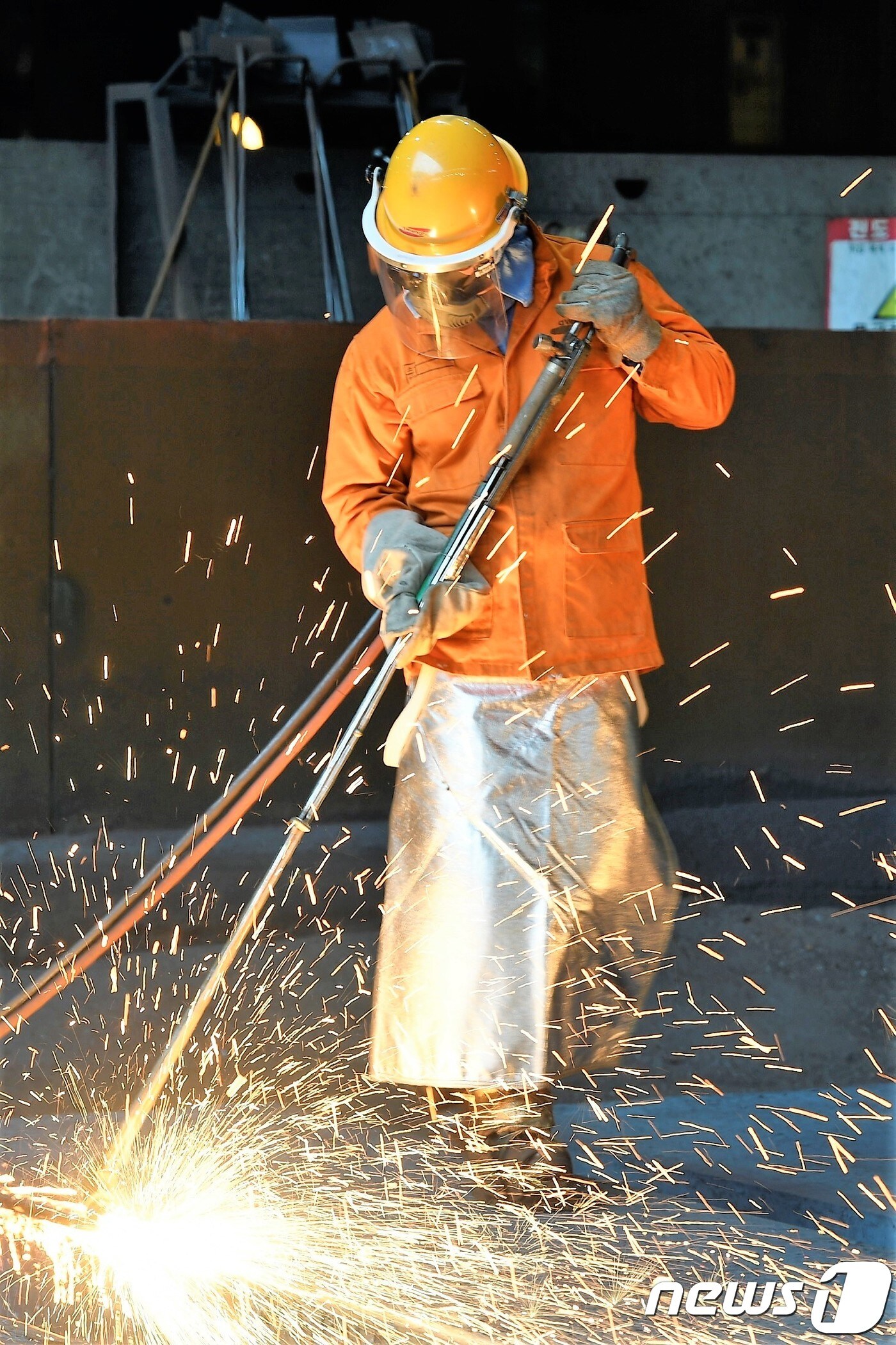 기록적인 폭염이 이어지는 6일 광양제철소 제강부 1연주공장에서 방열복을 입은 근로자가 철강 반제품인 '슬라브'의 표면을 불꽃으로 다듬는 '스카핑(scarfing)'작업을 하고 있다.(독자 제공)2018.8.6/뉴스1 ⓒ News1