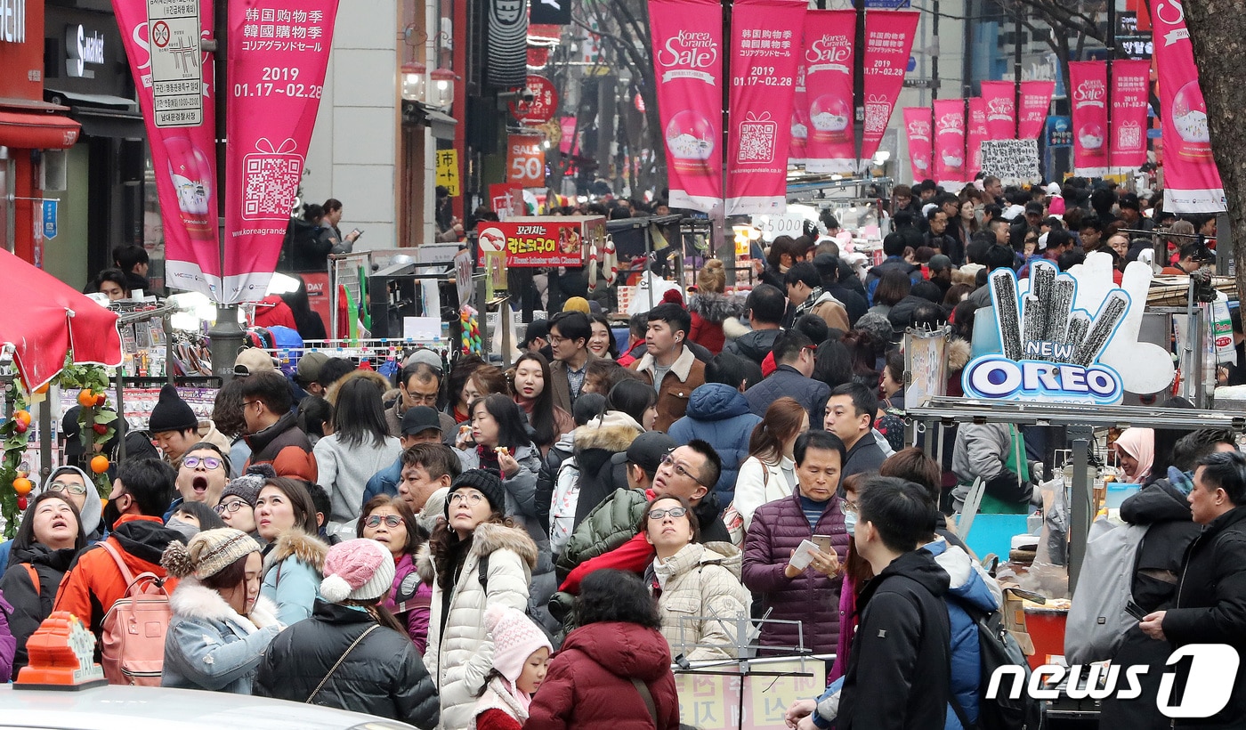 춘절을 맞아 한국을 찾은 중국인 관광객들이 서울 명동에 걸린 코리아 그랜드 세일 안내 현수막을 따라 걷고 있다. .2019.2.6 ⓒ 뉴스1 이종덕 기자
