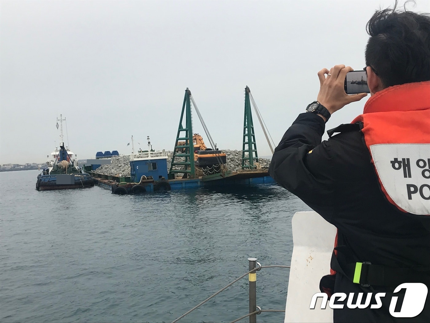 해경이 25일 오후 7시10분 제주항 인근에서 만재흘수선을 초과한 선적을 적발하고 있다(제주해경 제공)ⓒ 뉴스1