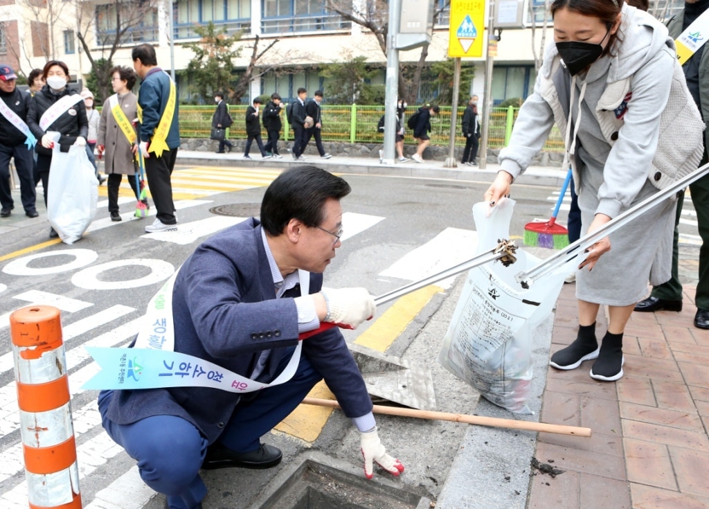 성장현 구청장이 27일 이촌1동 클린데이 행사에서 빗물받이에 쌓인 오물을 걷어내고 있다(용산구 제공).ⓒ 뉴스1