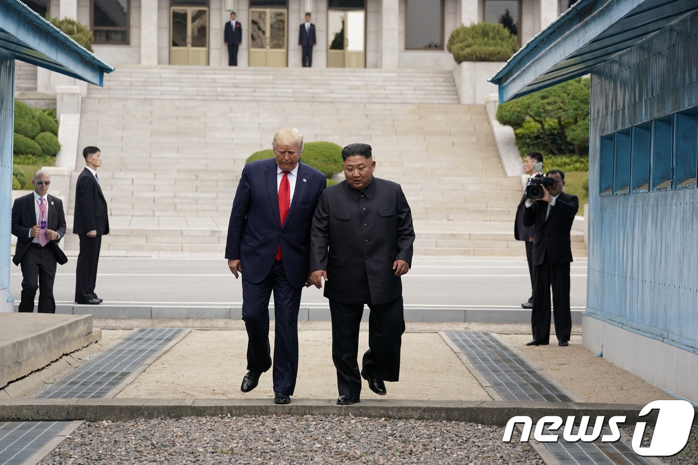 도널드 트럼프 미국 대통령이 지난 2019년 6월 30일 판문점을 방문해 북측에서 악수를 나눈 후 김정은 북한 국무위원장과 함께 남측으로 넘어오고 있다 ⓒ 로이터=뉴스1