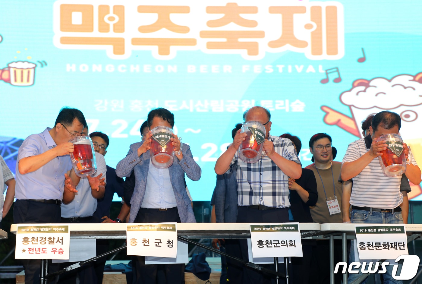 24일 강원 홍천군 토리숲 일대에서 개막한 홍천강 별빛음악 맥주축제에서 맥주 빨리 마시기 대회가 열리고 있다. 대회에는 군청, 의회, 경찰서, 소방서 등 지역 기관이 참여했다. 2019.7.24/뉴스1 ⓒ News1 하중천 기자