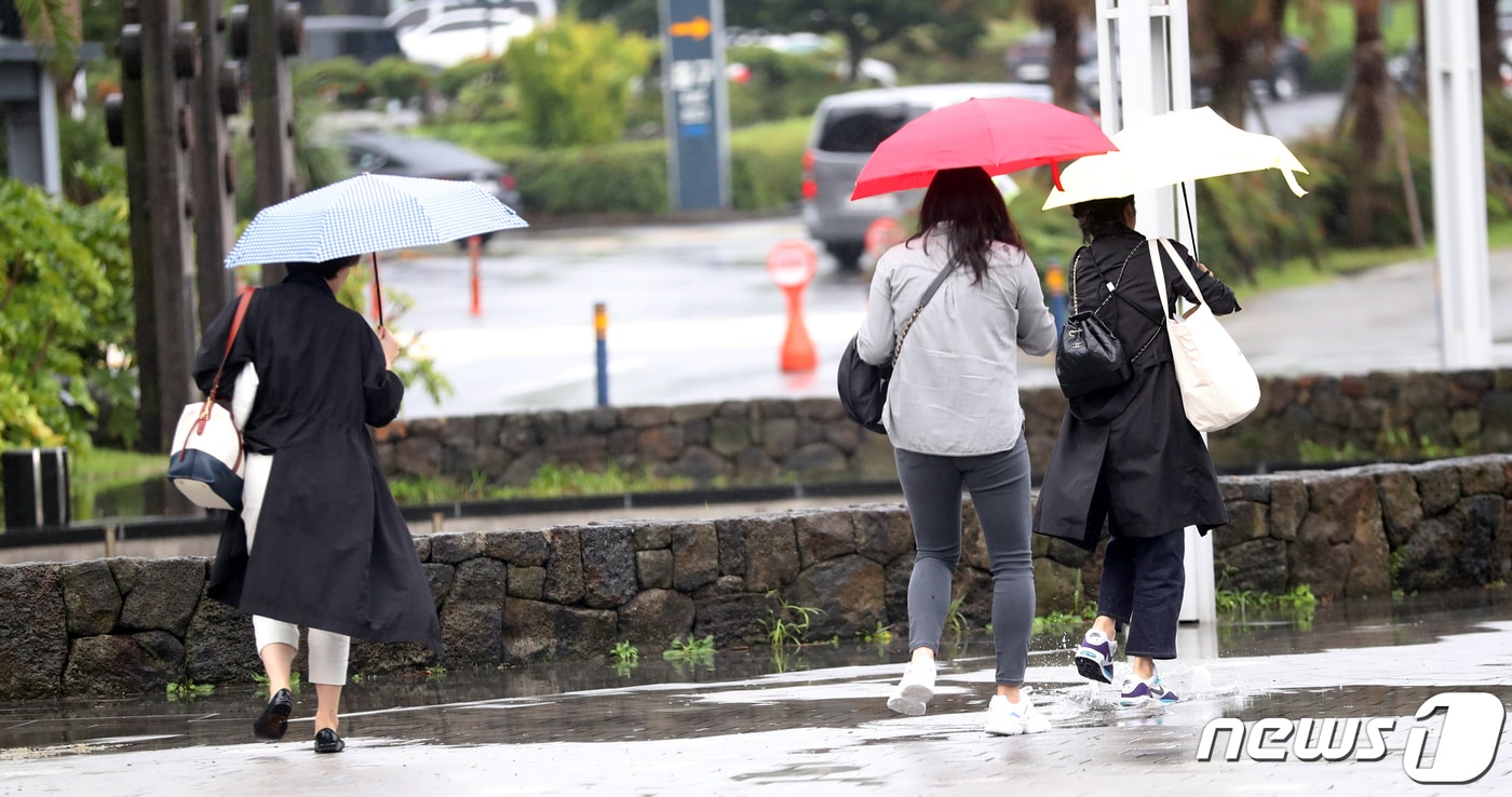 제주국제공항에서 사람들이 우산을 쓰고 걸어가고 있다./뉴스1 ⓒ News1 오현지 기자