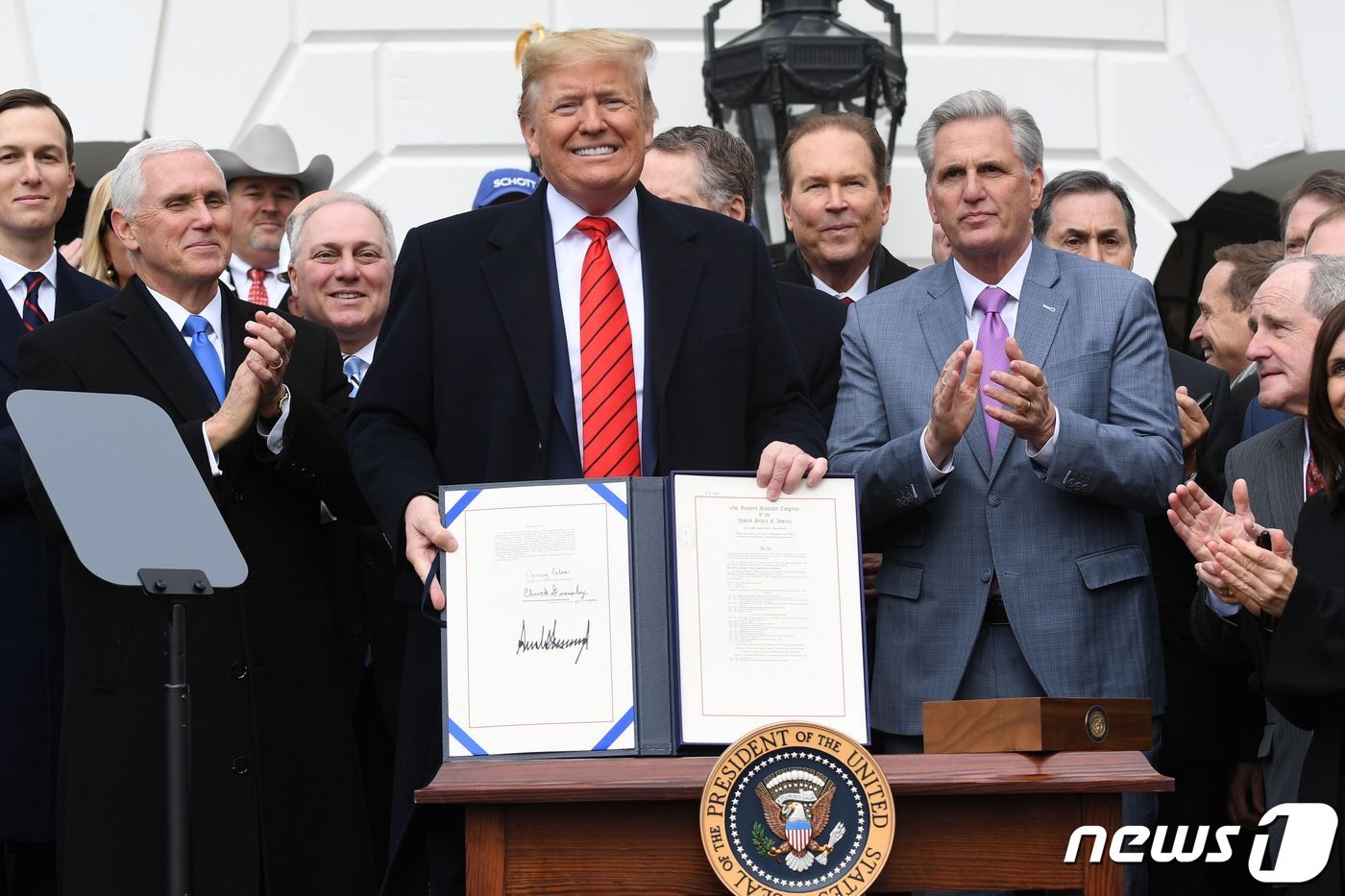 도널드 트럼프 미국 대통령이 29일(현지시간) 워싱턴 백악관에서 기존 북미자유무역협정(NAFTA)을 대체하는 새 북미무역협정인 미국·멕시코·캐나다 협정(USMCA) 서명문서을 들고 있다. ⓒ AFP=뉴스1