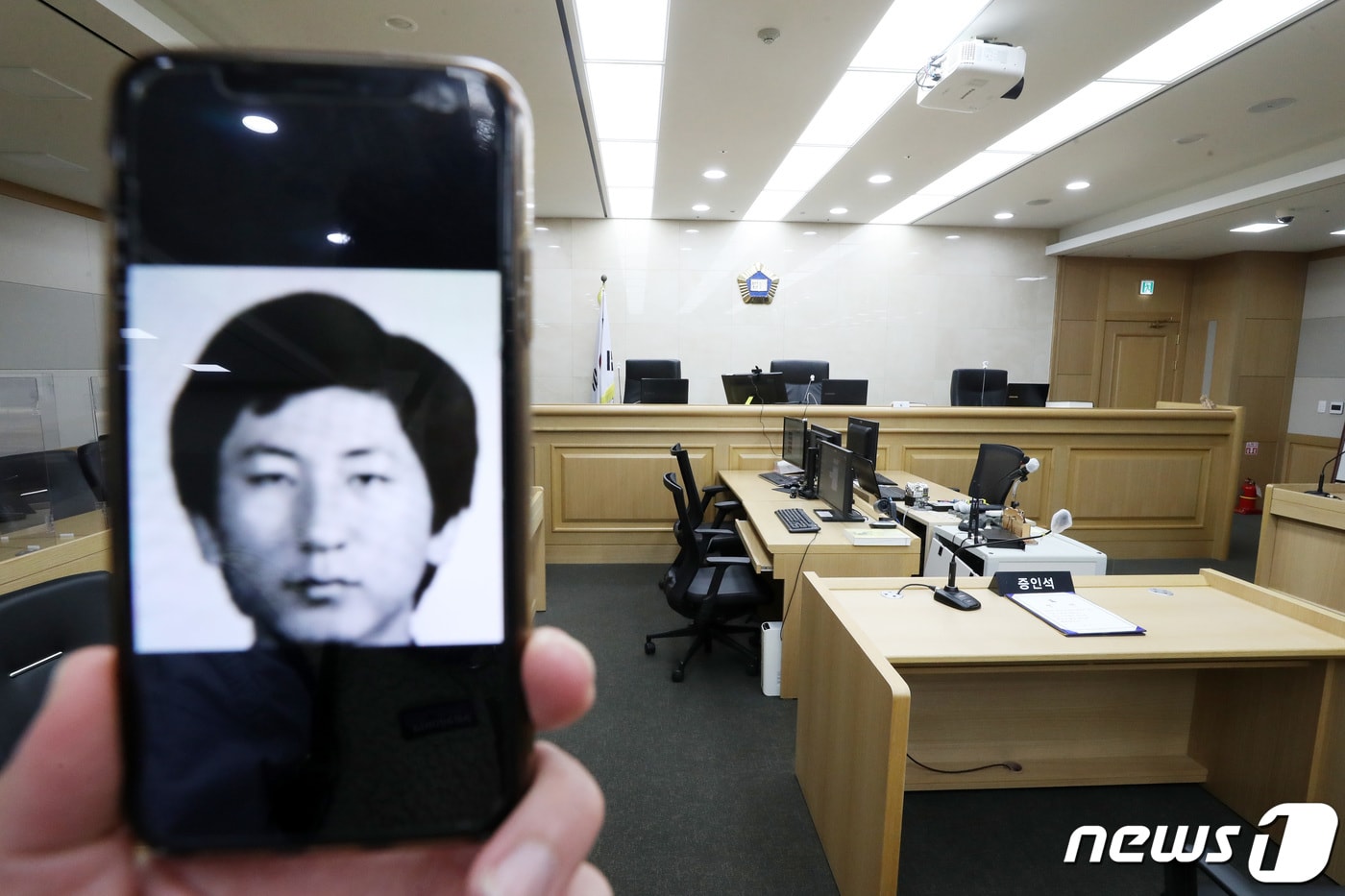 '이춘재 연쇄살인' 9차 사건 범인으로 억울하게 구속 수사를 받았던 고(故) 윤동일 씨가 재심에서 '무죄'를 선고 받았다. 사진은 휴대폰에 담긴 이춘재 얼굴과 그가 2020년 11월2일 증인으로 출석했던 경기도 수원시 영통구 수원지방법원 501호 법정. 2020.11.2/뉴스1 ⓒ News1 조태형 기자