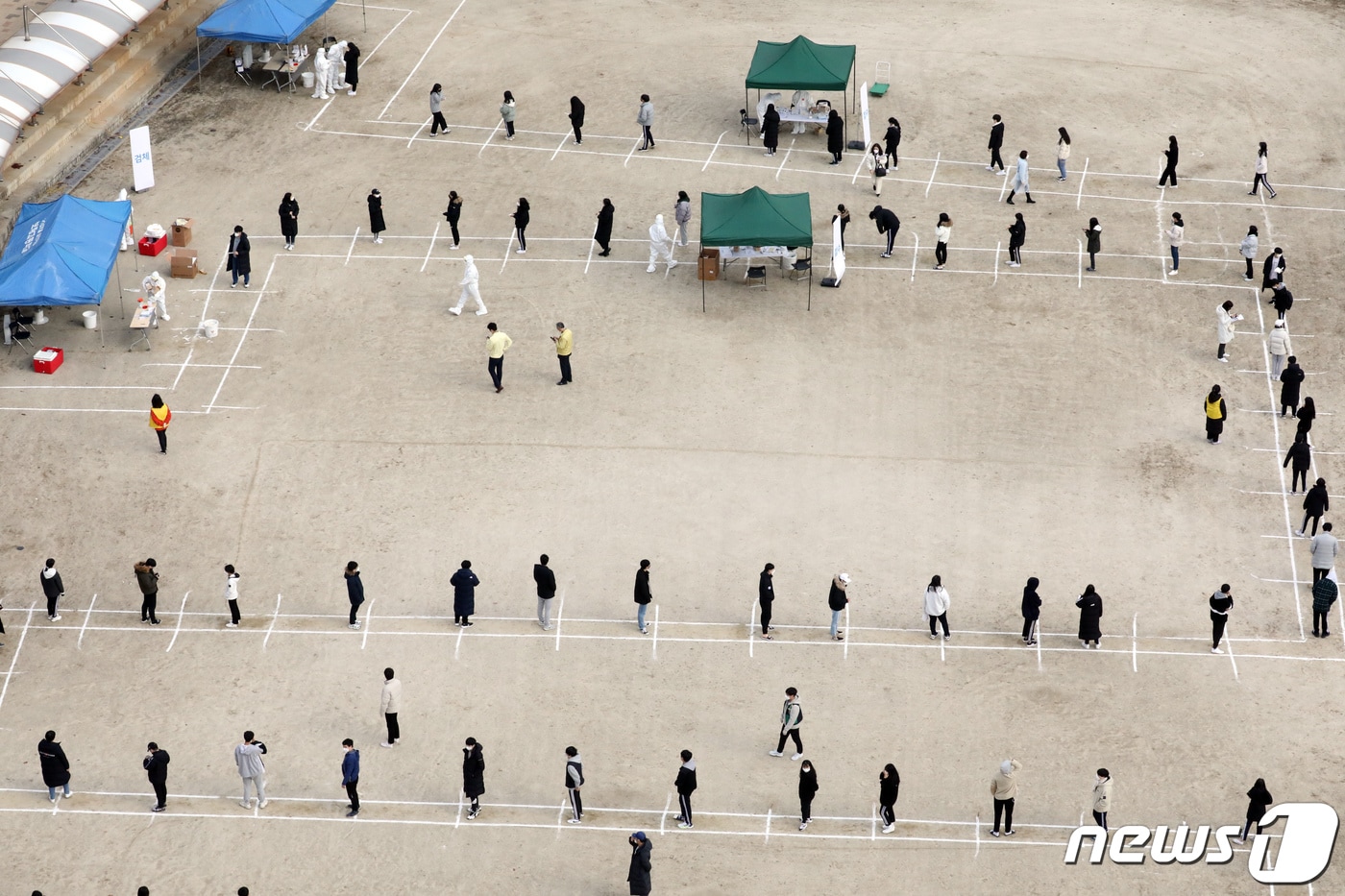지난 11월27일 수능을 엿새 앞두고 세종시의 한 고등학생 2명이 코로나19 확진 판정을 받아 방역당국이 전 학생과 교직원 등 587명을 대상으로 전수조사를 진행했다. 학생들이 운동장에서 코로나19 검사를 기다리고 있는 모습. 2020.11.27 /뉴스1 ⓒ News1 장수영 기자