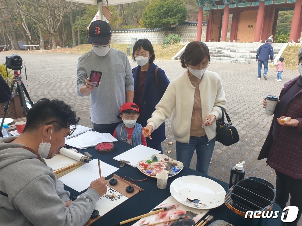 충남 부여군 부소산을 찾은 관광객들이 백제문화체험 프로그램에 관심을 보이고 있다.(부여군 제공)ⓒ 뉴스1
