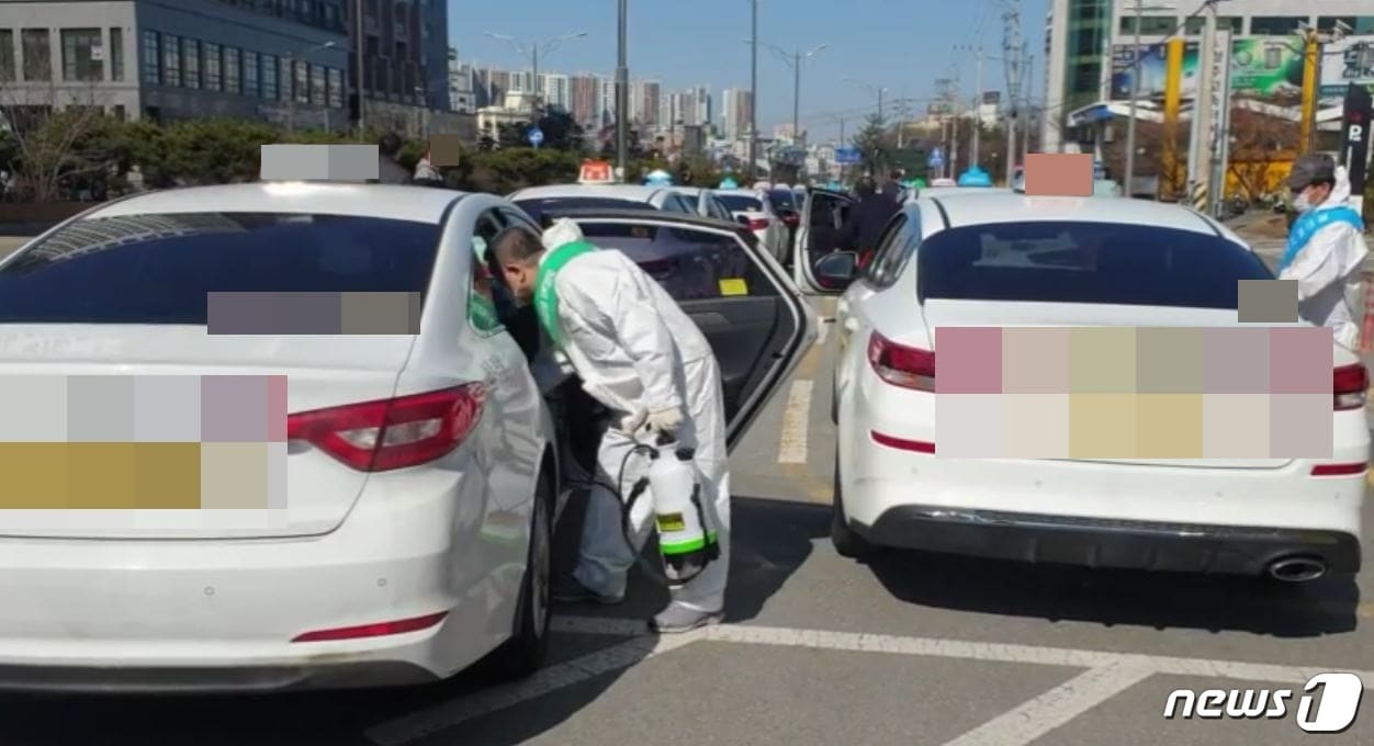22일 오전 충북 청주고속버스터미널 인근 택시승강장에서 개인택시 청주시지부 관계자들이 택시를 소독하고 있다. (독자 제공) ⓒ 뉴스1