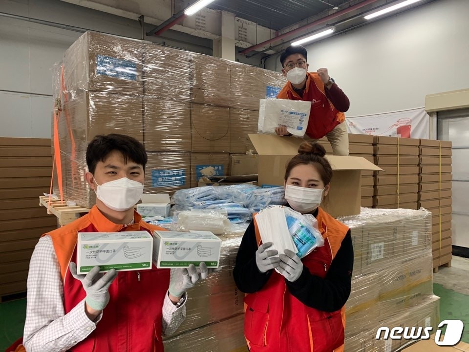 중국 우시시 정부가 보낸 코로나19 방역 마스크를 SK하이닉스 구성원들이 들어 보이고 있다.(SK하이닉스 제공)2020.03.18/뉴스1 ⓒ 뉴스1
