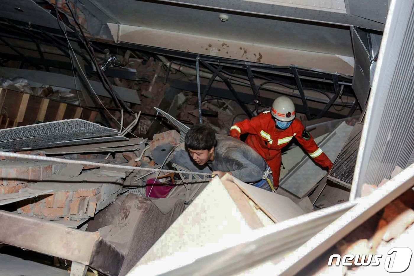 7일 붕괴된 신자호텔에서 한 시민이 소방대원의 도움을 받고 탈출하고 있다. ⓒ AFP=뉴스1 ⓒ News1 박형기 기자