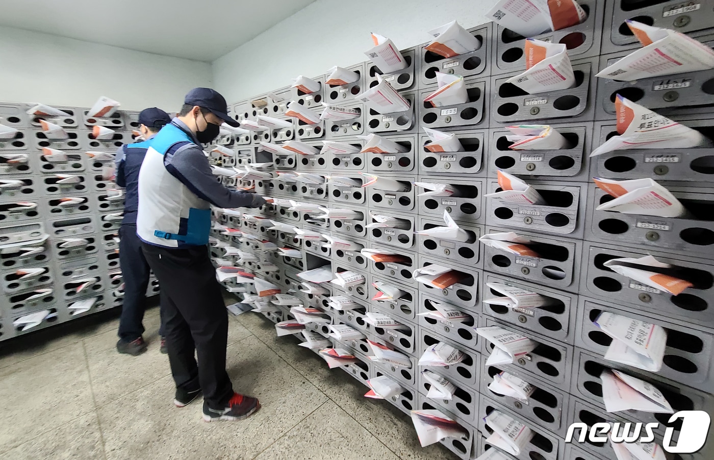 4·15 총선을 열흘 앞둔 5일 서울 마포구의 한 아파트에서 마포우체국 집배원들이 투표안내문·선거공보물을 우편함에 넣고 있다. 2020.4.5/뉴스1 ⓒ News1 허경 기자