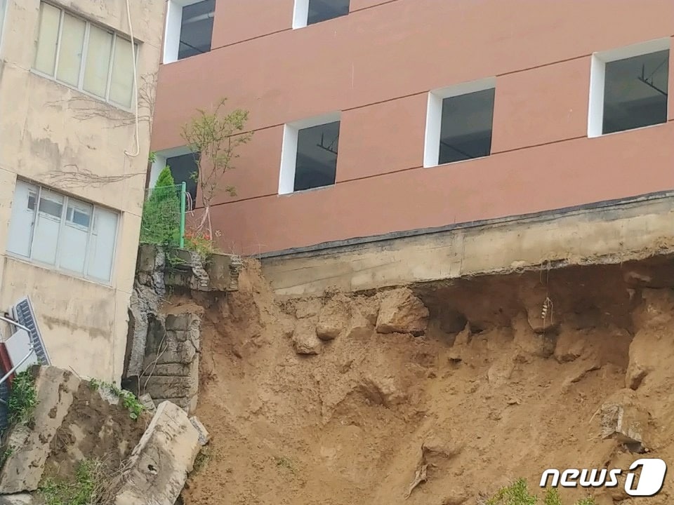 30일 오전 8시10분쯤 부산 금정구 구서동의 한 아파트와 인근 신축공사장 사이에 있던 축대가 호우로 무너져 내렸다. 축대가 붕괴돼 흙과 모래가 쓸려내려온 모습.(부산지방경찰청 제공)ⓒ 뉴스1
