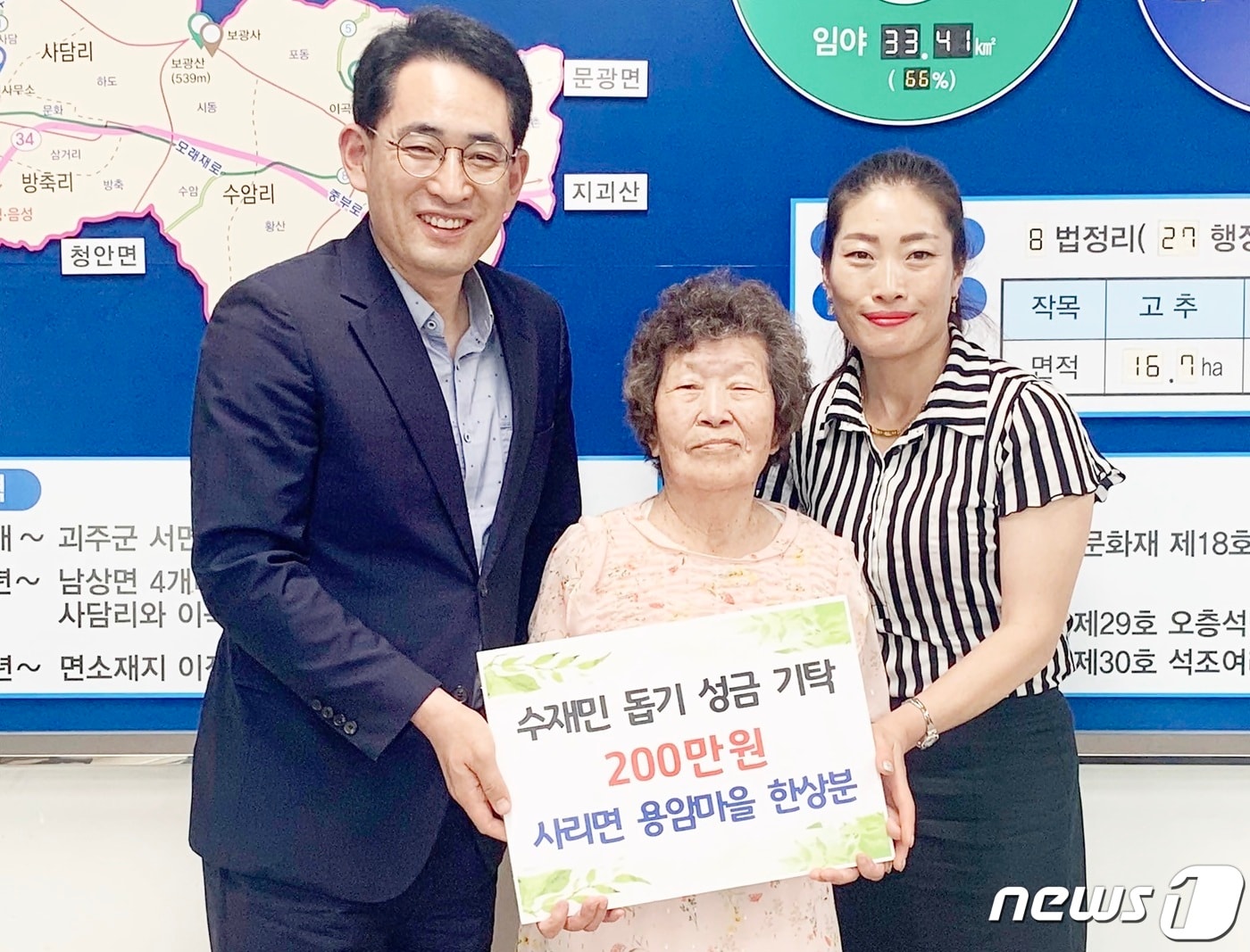 괴산군 사리면 한상분씨가 주민자치센터에 수재민을 위해 써달라며 절약해 모은 200만원을 전달하고 있다.(괴산군 제공)ⓒ 뉴스1