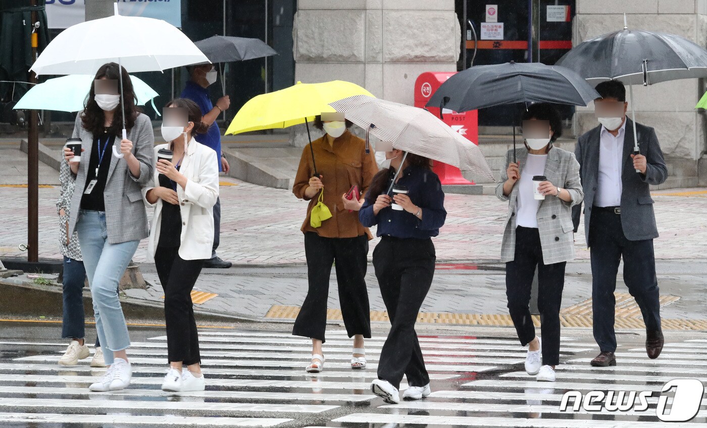 대전 서구 대전시청 인근 도로에서 시민들이 우산을 쓰고 이동하고 있다.  ⓒ News1 김기태 기자