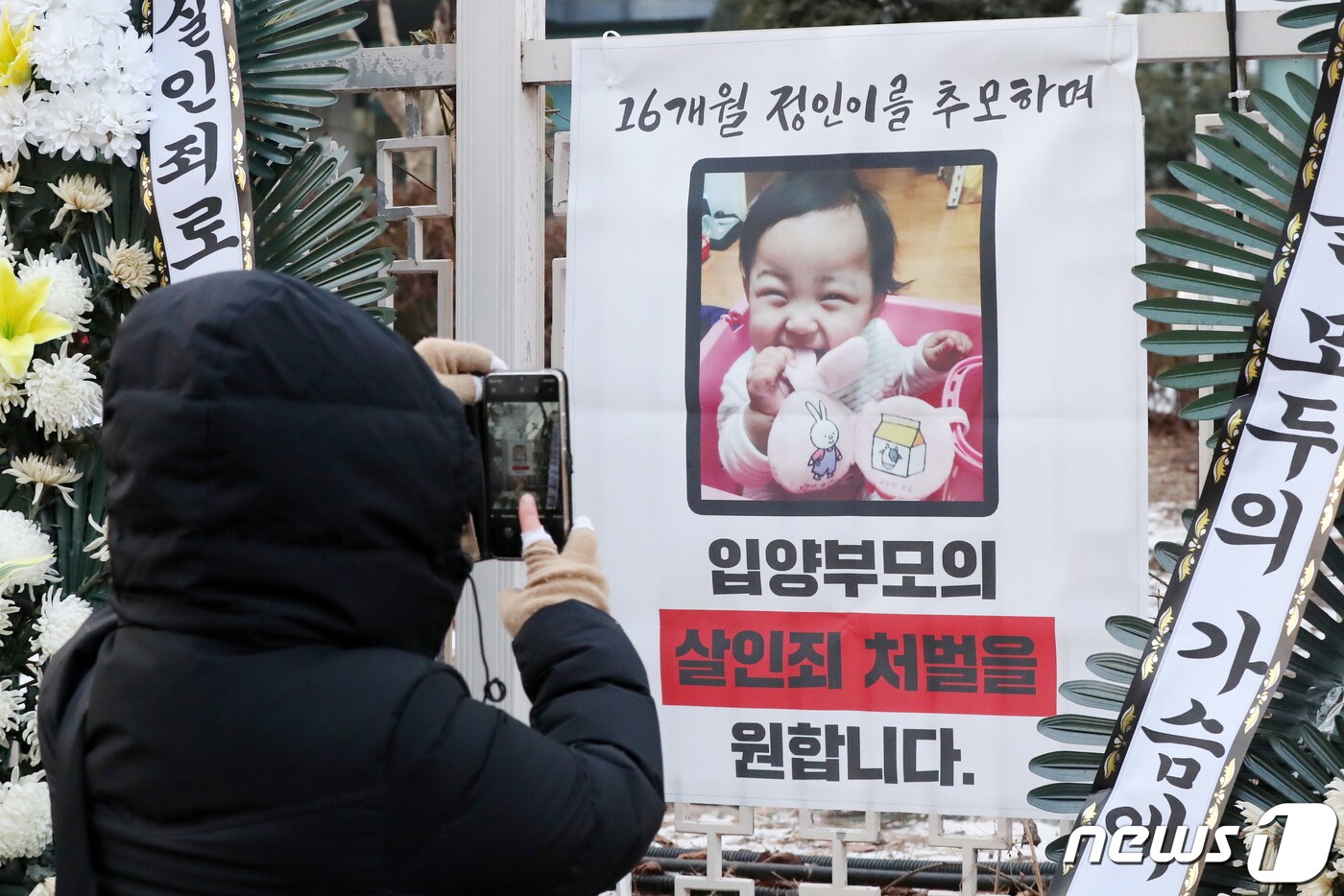 12일 오전 서울 양천구 남부지방검찰청 앞에 마련된 정인이를 위한 추모 공간에서 한 시민이 정인이의 모습을 휴대전화 카메라에 담고 있다. 2021.1.12/뉴스1 ⓒ News1 민경석 기자