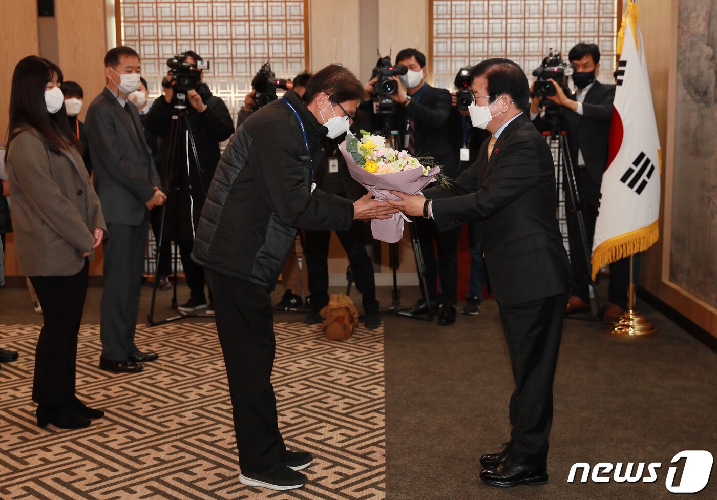 박병석 국회의장이 4일 오후 서울 여의도 국회에서 열린 ‘민간근로자 정규직 전환 기념행사’에서 참석자에게 축하 꽃다발을 전달하고 있다. 2021.1.4/뉴스1 ⓒ News1 박세연 기자