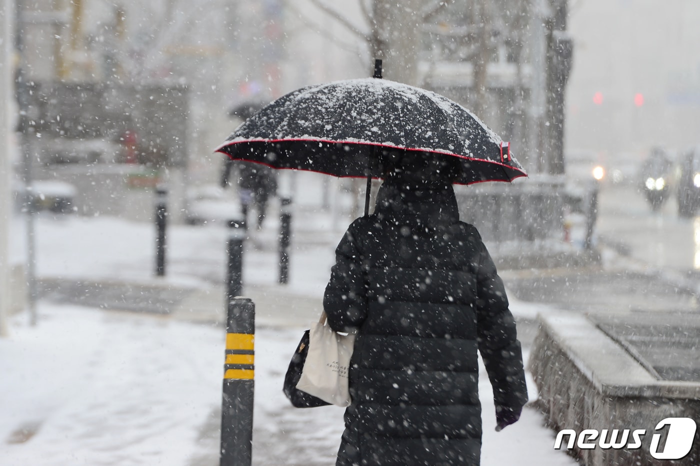 17일 오후 광주 서구 쌍촌동 한 인도에서 시민들이 내리는 눈을 피해 이동하고 있다. 2021.12.17/뉴스1 ⓒ News1 정다움 기자