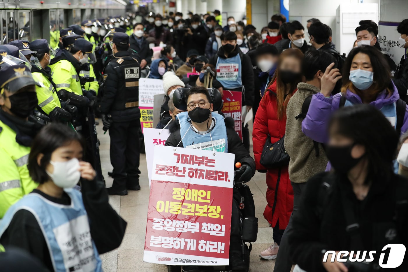 전국 장애인차별철폐연대 회원들이 지난해 12월20일 오전 서울 종로구 지하철 5호선 광화문역에서 장애인 이동권 보장을 촉구하며 공덕역으로 이동하기 위해 집결하고 있다. 2021.12.20/뉴스1 ⓒ News1 이재명 기자