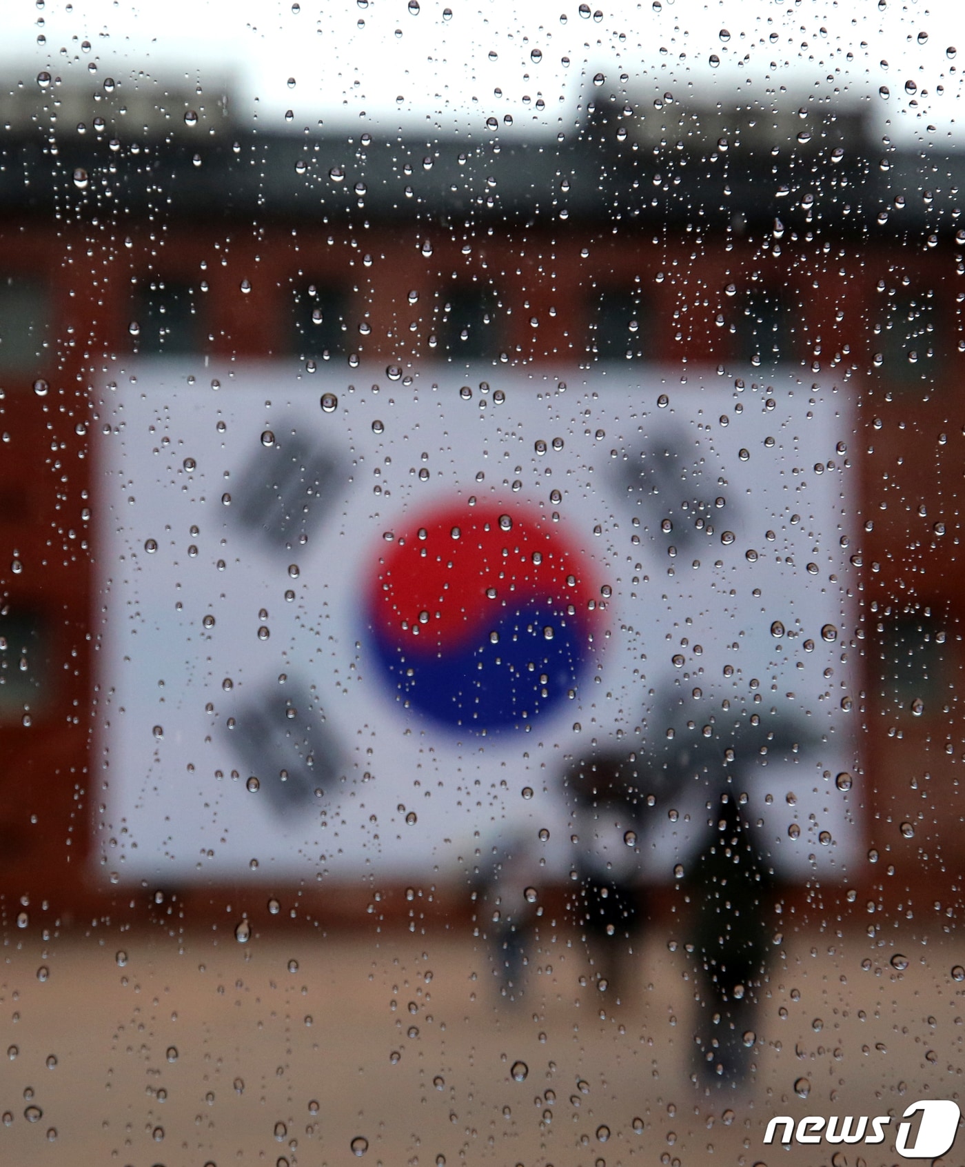 제102주년 3·1절인 1일 오후 서울 서대문형무소역사관에 설치된 대형 태극기 앞 유리에 빗물이 맺혀있다. 이날 서대문형무소역사관 관람은 신종 코로나바이러스 감염증&#40;코로나19&#41; 감염 예방 및 확산 방지를 위해 사전예약제로 승인된 관람객에 한해 진행됐다. 2021.3.1/뉴스1 ⓒ News1 구윤성 기자