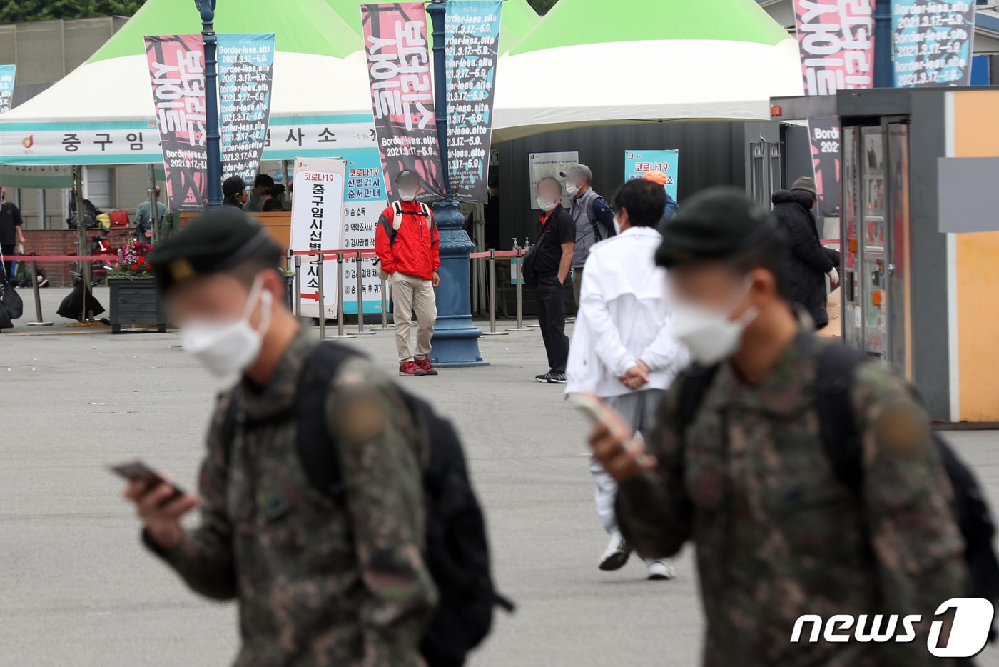 27일 서울 중구 서울역광장에 마련된 신종 코로나바이러스 감염증(코로나19) 임시선별진료소 앞에서 군인들이 발걸음을 옮기고 있다. 이날 국방부는 30세 이상 군 장병 등에 대한 신종 코로나바이러스 감염증(코로나19) 백신 접종을 오는 28일 시작해 5월 첫째 주까지 마무리할 계획이라고 밝혔다. 2021.4.27/뉴스1 ⓒ News1 황기선 기자