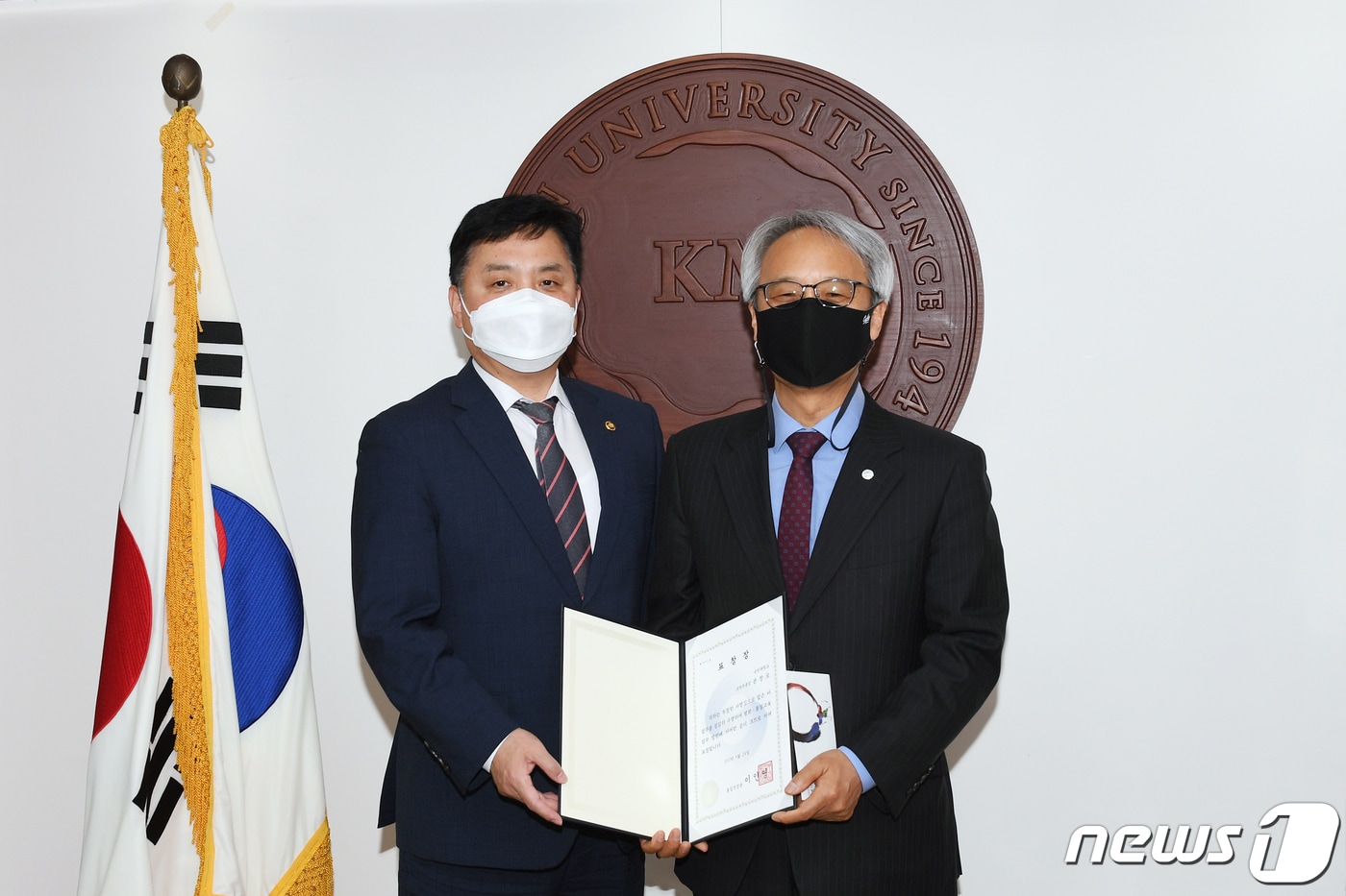 최영준 통일부 차관(왼쪽)이 문창로 국민대 교학부총장(오른쪽)에게 통일부장관상을 수여한 후 기념촬영을 하고 있다. (국민대 제공) ⓒ 뉴스1