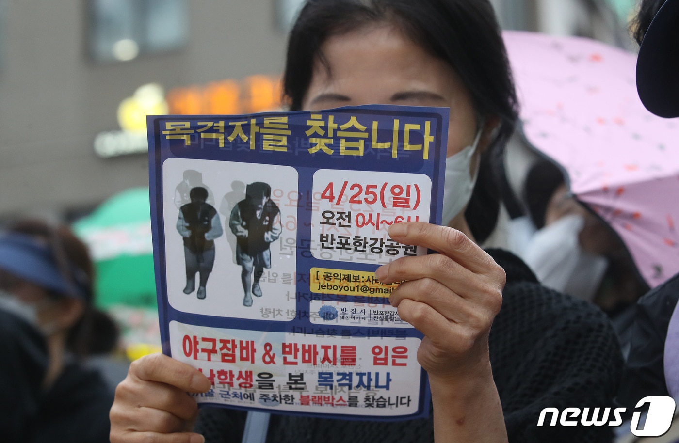 지난 5월 서울 서초구 반포동 반포쇼핑센터 인근에서 열린 故 손정민 씨 사망 진상규명 촉구 집회에서 시민들이 故 손정민 씨 사건 목격자를 찾는 전단지를 들어보이고 있다. ⓒ News1 임세영 기자