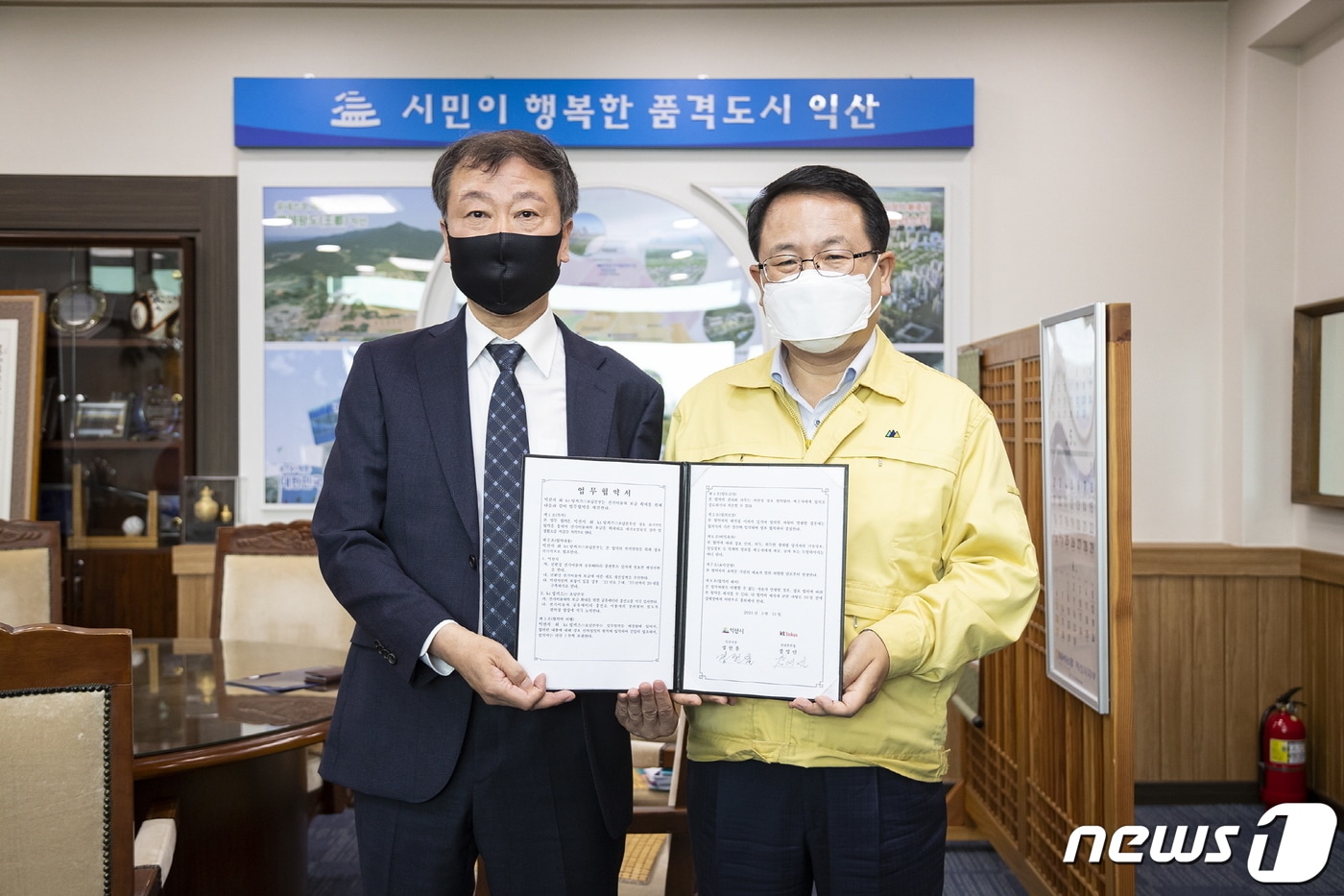 정헌율 익산시장(오른쪽)과 장영민 KT링커스 호남본부장이 ‘전기이륜차 배터리 교환형 충전인프라 구축’을 위한 업무협약을 체결하고 있다(익산시 제공)2021.5.31/뉴스1