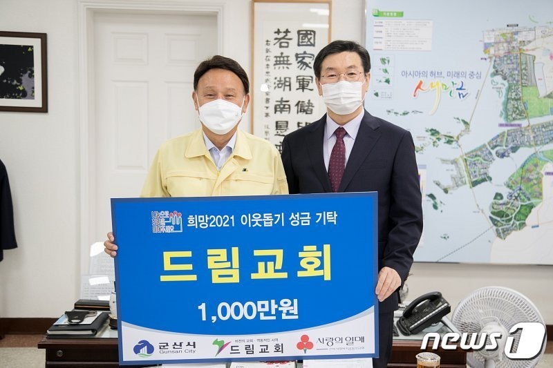 임만호 군산드림교회 담임목사(사진 오른쪽)가 강임준 군산시장에게 이웃돕기 성금을 기탁하고 있다.ⓒ 뉴스1