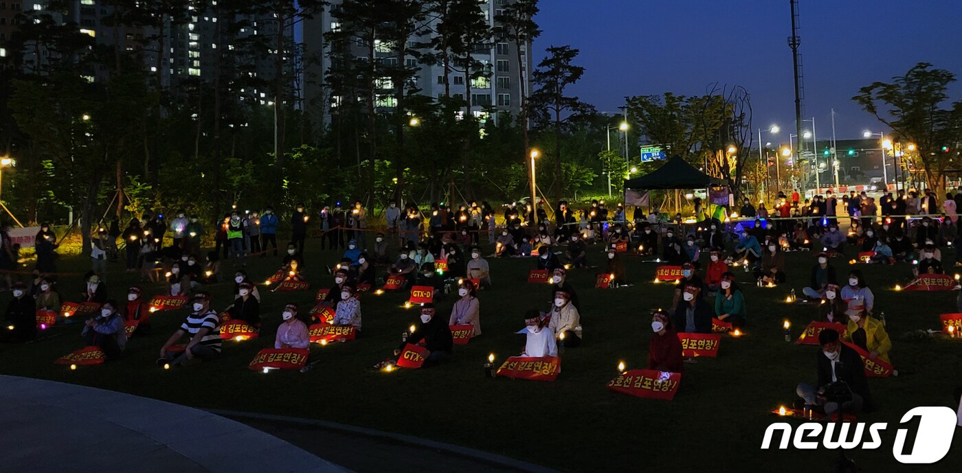 GTX-D원안 및 지하철 5호선 연장을 요구하는 김포·인천 검단 주민들이 5일 김포시 장기동 한강중앙공원에서 촛물문화제를 열고 있다.(김포검단교통시민연대제공) 2021.6.5/뉴스1 ⓒ News1 정진욱 기자