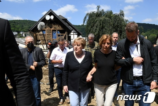 2021년 7월 18일 앙겔라 메르켈 독일 총리(좌)가 현재까지 112명의 사망자를 낸 라인란트-팔레티나테주의 말루 드레이어 주지사의 손을 잡고 피해지역을 둘러보고 있다. ⓒ 로이터=뉴스1