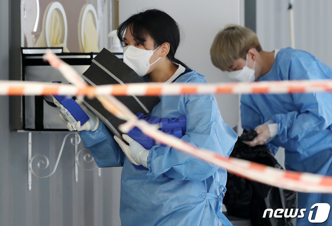 1년 중 더위가 가장 심하다는 절기 '대서'인 22일 오전 경기도 고양시 화정역 광장 선별진료소에서 한 의료진이 아이스팩을 챙겨 동료들에게 나눠주고 있다. 2021.7.22/뉴스1 ⓒ News1 이동해 기자