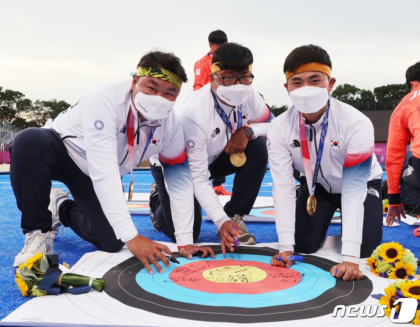 양궁 오진혁, 김우진, 김제덕이 26일 일본 도쿄 유메노시마 공원 양궁장에서 열린 2020 도쿄올림픽 양궁 남자단체전 시상식을 마치고 과녁판에 사인을 한 뒤 포즈를 취하고 있다. 2021.7.26/뉴스1 ⓒ News1 송원영 기자