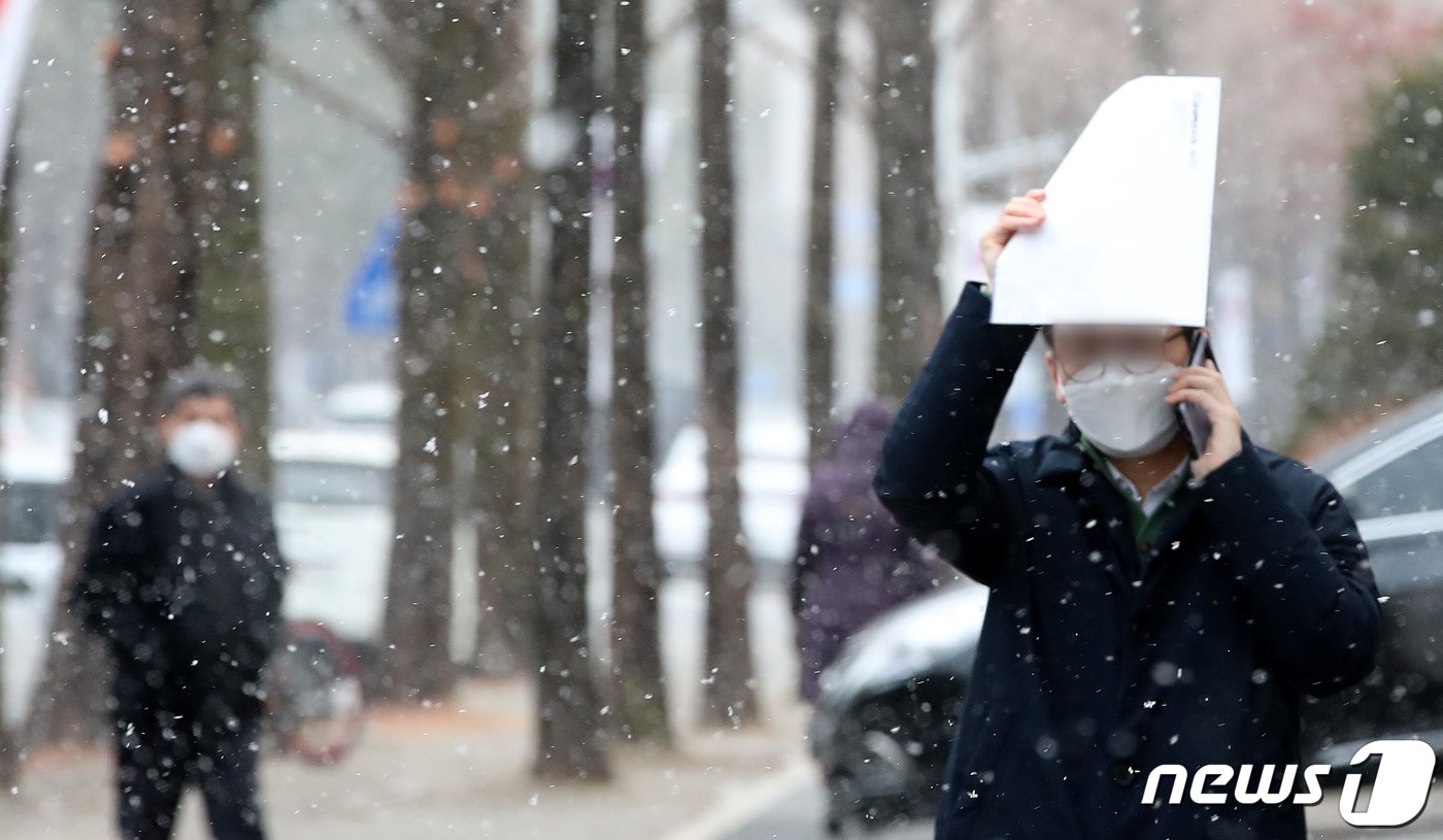 한파특보가 내려진 대전·충남에 하루 사이 1~5㎝의 눈이 내린 뒤 현재 소강상태를 보이고 있다. 대전 서구 보라매공원 일대에서 시민이 눈을 맞으며 이동하고 있다. /뉴스1 ⓒ News1 김기태 기자