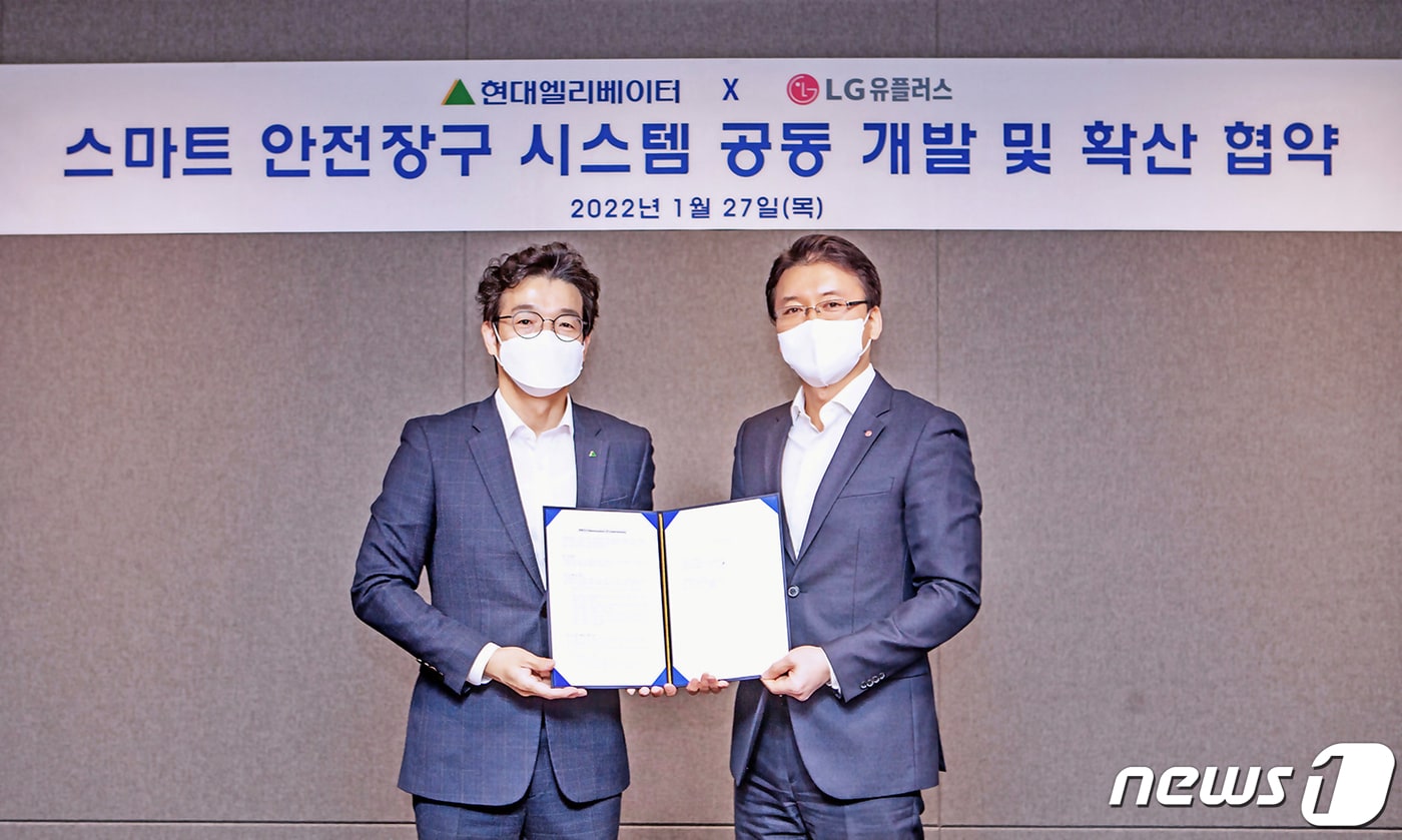 LG유플러스는 현대엘리베이터와 '스마트 안전장구 시스템 공동 개발 및 확산 협력'에 관한 업무협약(MOU)을 27일 체결했다고 밝혔다. 사진은 전승훈 LG유플러스 스마트인프라사업담당 상무(오른쪽)와 이정한 현대엘리베이터 최고안전환경책임자(왼쪽)가 기념 촬영하고 있는 모습 (LGU+ 제공) ⓒ 뉴스1
