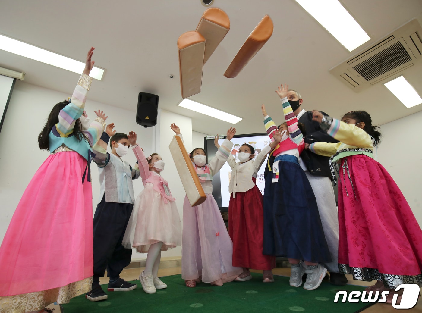 설 명절를 앞둔 27일 오후 울산 동구 현대외국인학교에서 열린 설 맞이 한국문화 체험 행사에서 한복을 곱게 차려 입은 외국인 학생들이 윷놀이를 하고 있다. 2022.1.27/뉴스1 ⓒ News1 윤일지 기자