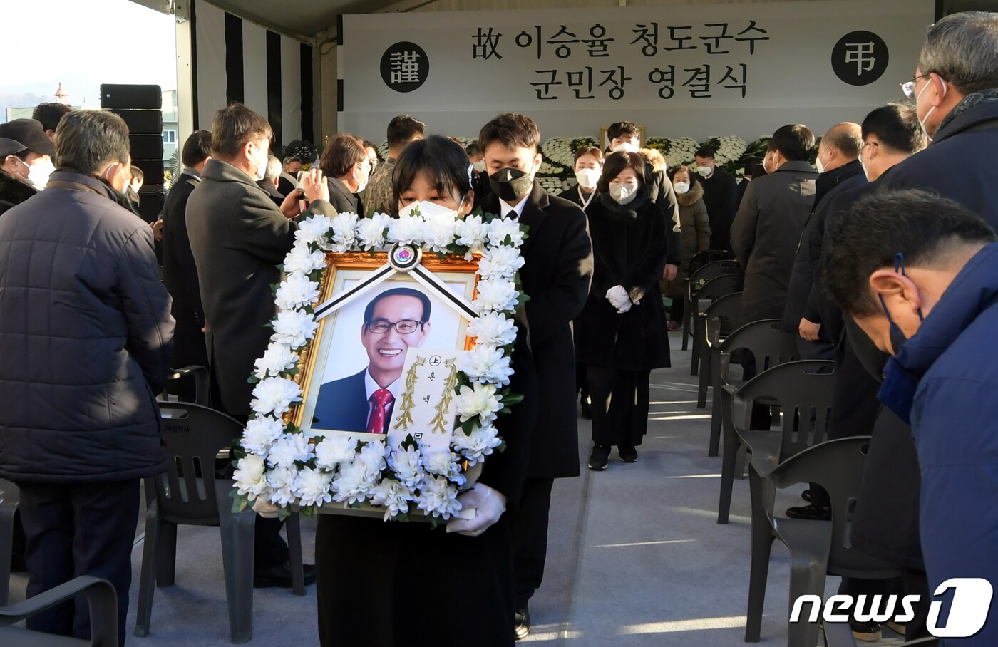 6일 오전 경북 청도군청 광장에서 고 이승율 군수 영결식이 엄수됐다. 고인의 큰딸 이윤정씨가 영정사진을 들고 영결식장을 나오고 있다. (청도군 제공) 2022.1.6/뉴스1 ⓒ News1 정우용 기자