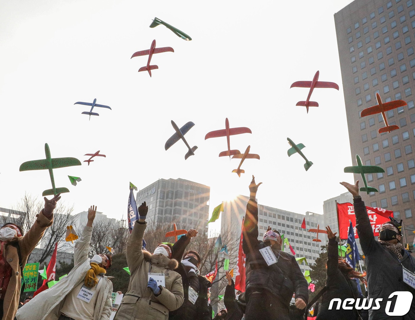 서울 종로구 보신각 앞에서 열린 여행인 총궐기대회에서 한국여행업협회 등 참석자들이 비행기 모형을 날리는 퍼포먼스를 하고 있다. 2022.1.9/뉴스1 ⓒ News1 성동훈 기자
