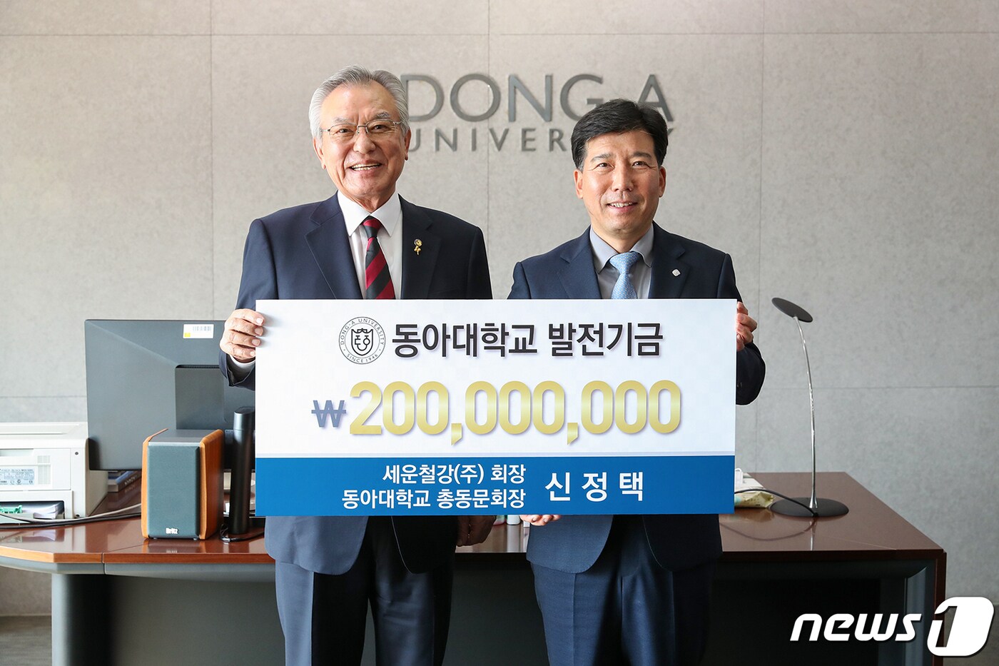 신정택 ㈜세운철강 회장(왼쪽)이 지난 9일 동아대에 발전기금 2억원을 기부한 뒤 이해우 총장과 기념촬영을 하고 있다.(동아대 제공)