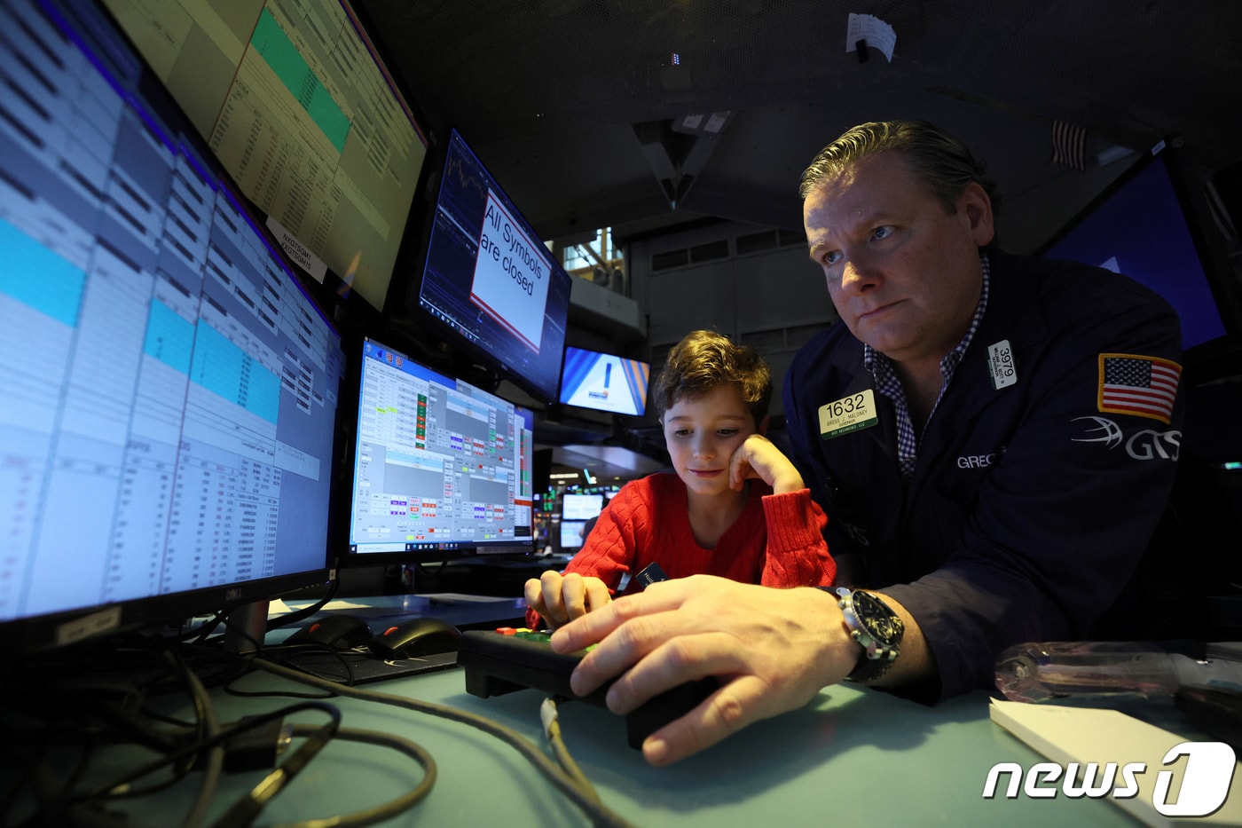 뉴욕증권거래소(NYSE) 내부 객장의 한 트레이더가 추수감사절 다음날인 블랙프라이데이 자녀를 데리고 와서 구경시켜 주는 행사에 참여하며 컴퓨터 화면을 쳐다 보고 있다. 2022.11.25 ⓒ 로이터=뉴스1