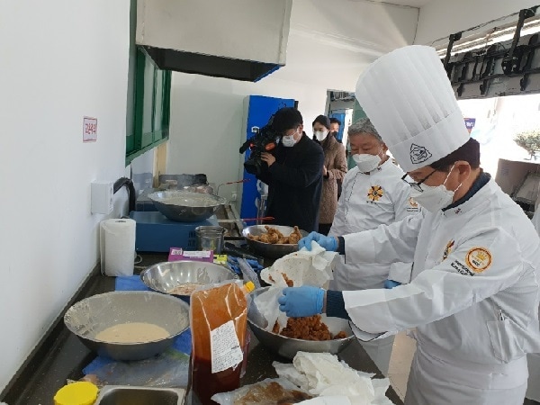 추창민 식품연구소장이 오리 후라이드를 양념소스에 버무리는 모습