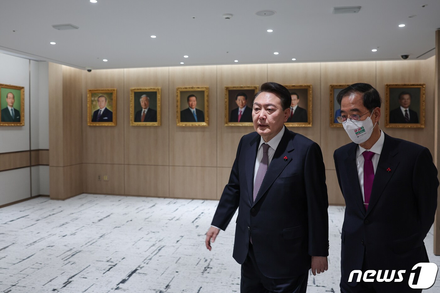 윤석열 대통령이 13일 용산 대통령실 청사에서 열린 국무회의에 참석하며 한덕수 총리와 대화하고 있다. 국무회의장 입구에 역대 대통령의 초상화가 전시돼 있다. &#40;대통령실 제공&#41; 2022.12.13/뉴스1 ⓒ News1 오대일 기자