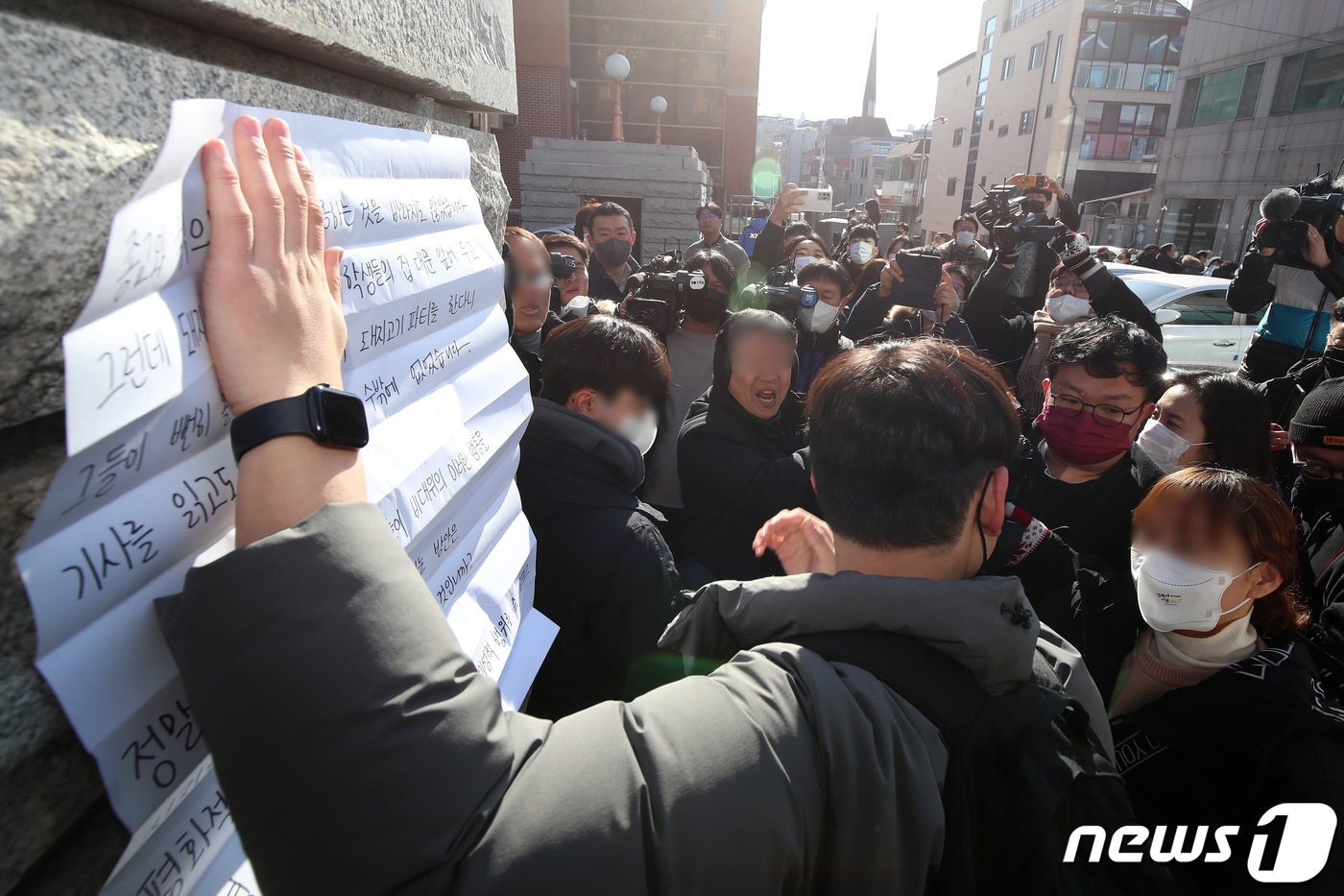 15일 오전 대구 북구 대현동 경북대 서문 앞에서 인근 주택가 이슬람사원 건축을 반대하는 주민들이 주최한 기자회견 도중 경북대 학생들이 '대현동 연말큰잔치를 규탄한다'는 내용의 대자보를 붙이려다 이를 반대하는 주민들과 설전을 벌이고 있다. 2022.12.15/뉴스1 ⓒ News1 공정식 기자