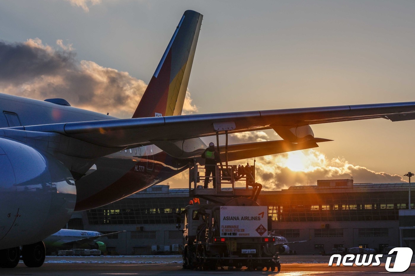 아시아나항공 관계자가 지난 22일 오전 인천국제공항 활주로에서 운항을 앞둔 비행기에 주유를 하며 마지막 점검을 하고 있다.2022.12.28/뉴스1 ⓒ News1 임세영 기자