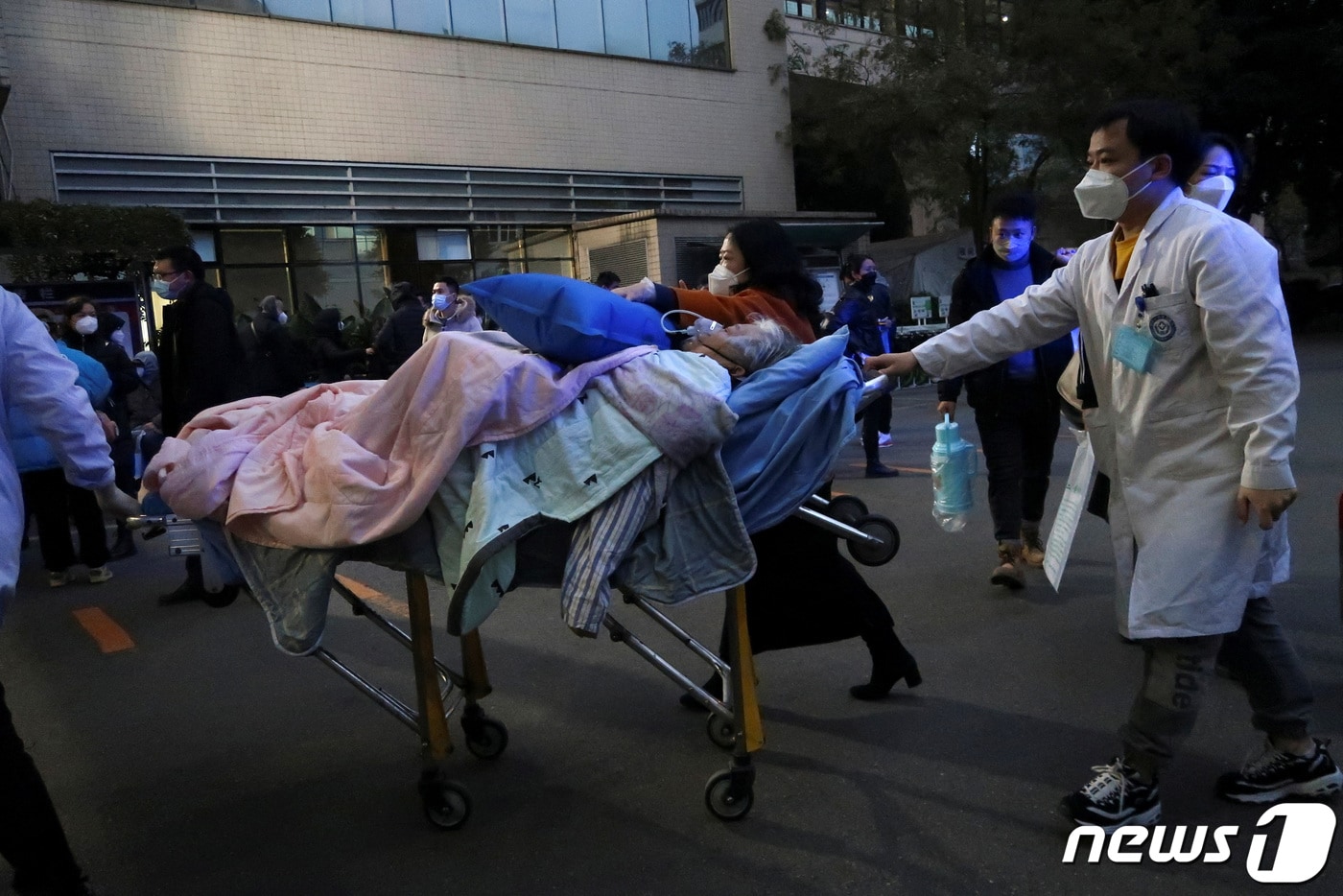 지난 12월 27일&#40;현지시간&#41; 중국 쓰촨성 청두에서 의료진이 코로나19에 감염된 고령 확진자를 들것에 실어 이송하고 있다. ⓒ 로이터=뉴스1 ⓒ News1 권진영 기자